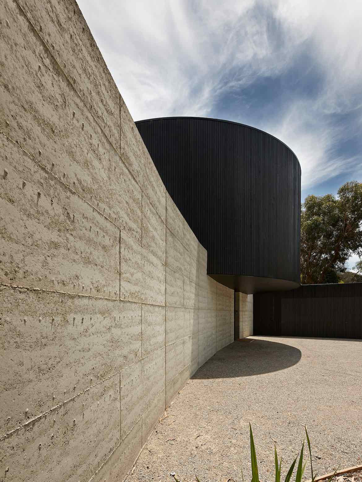 Large beige bricks make up the exterior rammed earth wall of Portsea House by Wood Marsh