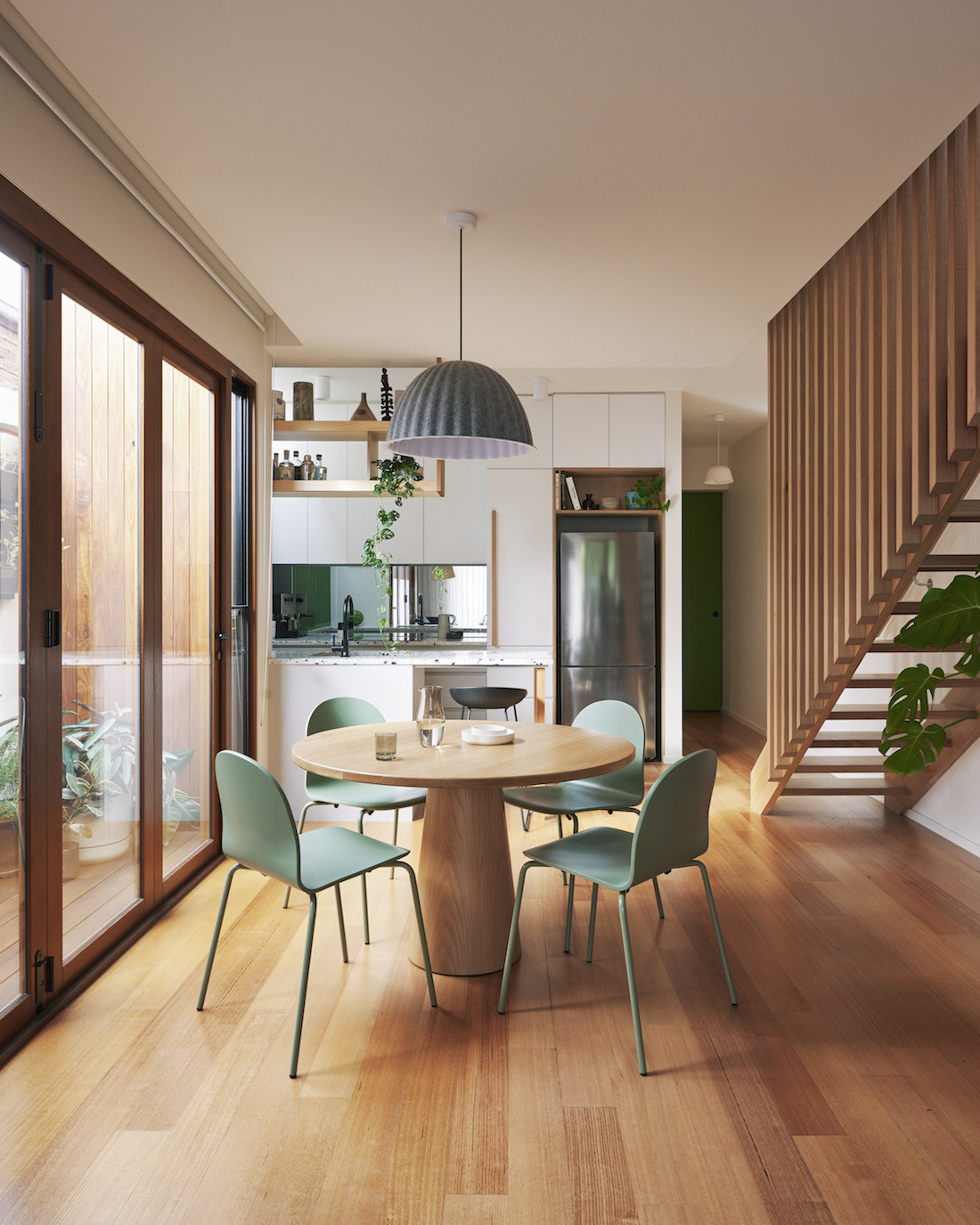 Dining table, floating staircase and kitchen of the Brunswick home.