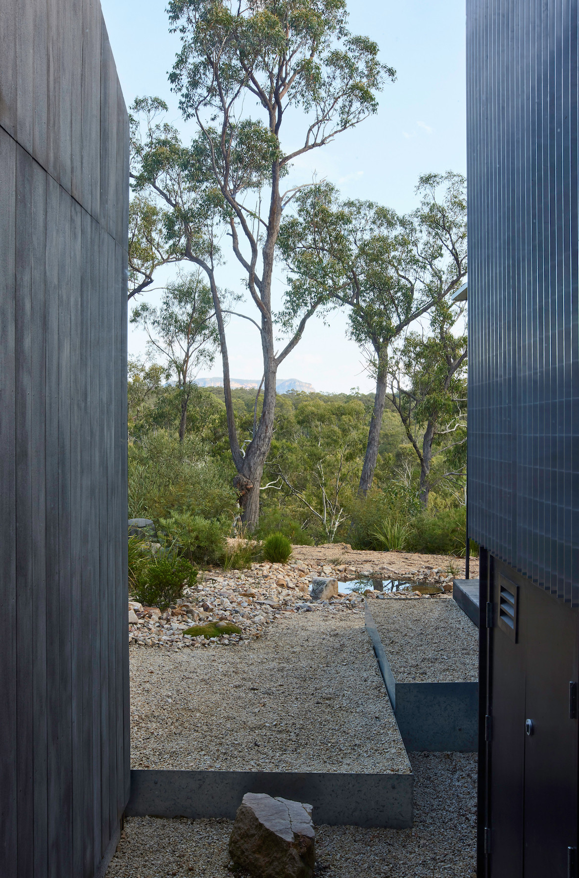 The fireproof timber cladding on two walls of Off Grid Home, with a view of Megalong Valley in the background.