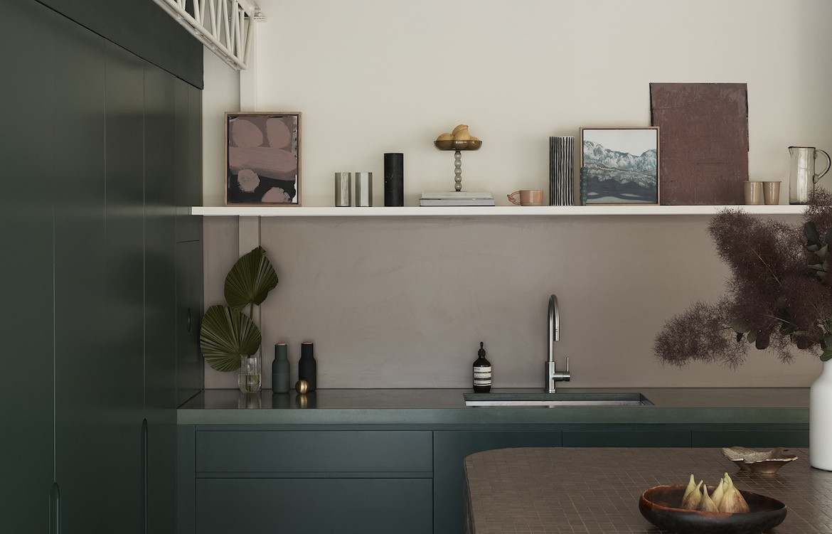 The dark green kitchen with white walls and a brown tiled mosaic island bench. Wahroonga House by Tom Mark Henry.