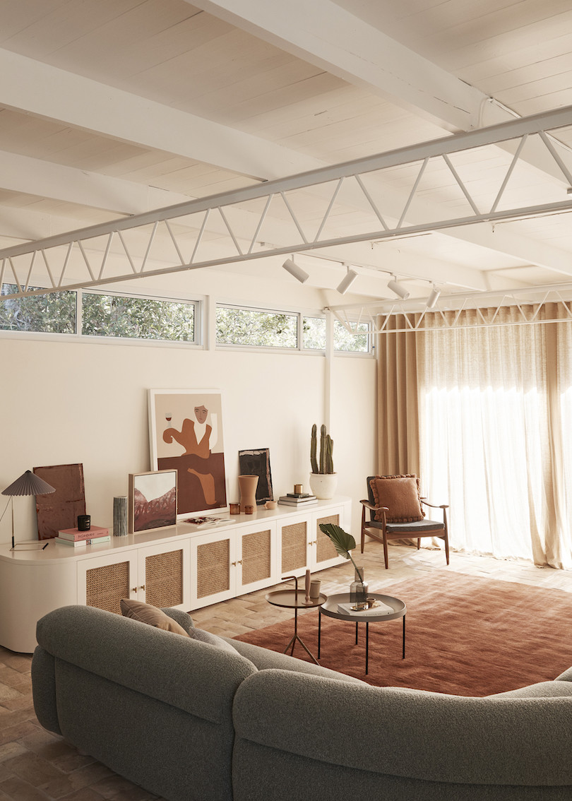 A loungroom with white walls and white timber ceiling with support trusses. Wahroonga House by Tom Mark Henry.