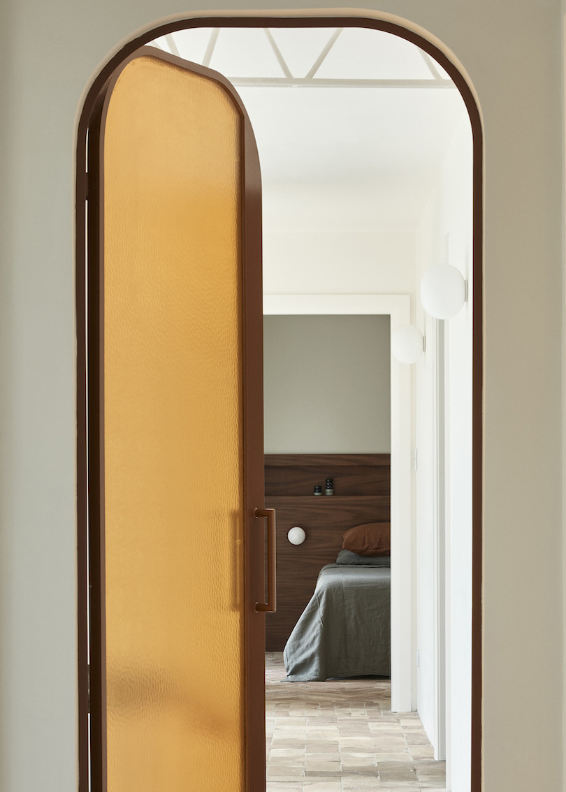 A frosted brown door to the bedroom in Bathroom with green tiles and white grout in the Wahroonga House by Tom Mark Henry.