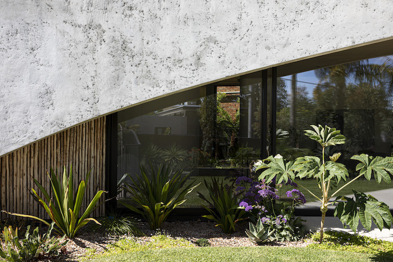 A close up of a concrete section, garden and windows of Brush House.