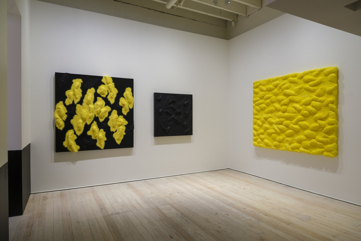 An arrangement of black and yellow paintings in big in china exhibition at the White Rabbit Gallery.