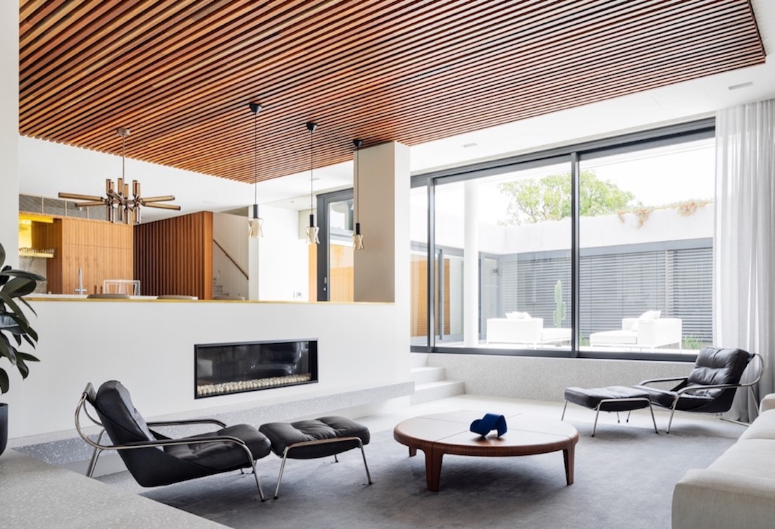 The sunken living room oriented around a fireplace.