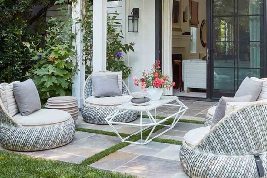 small stone patio with wicker chairs
