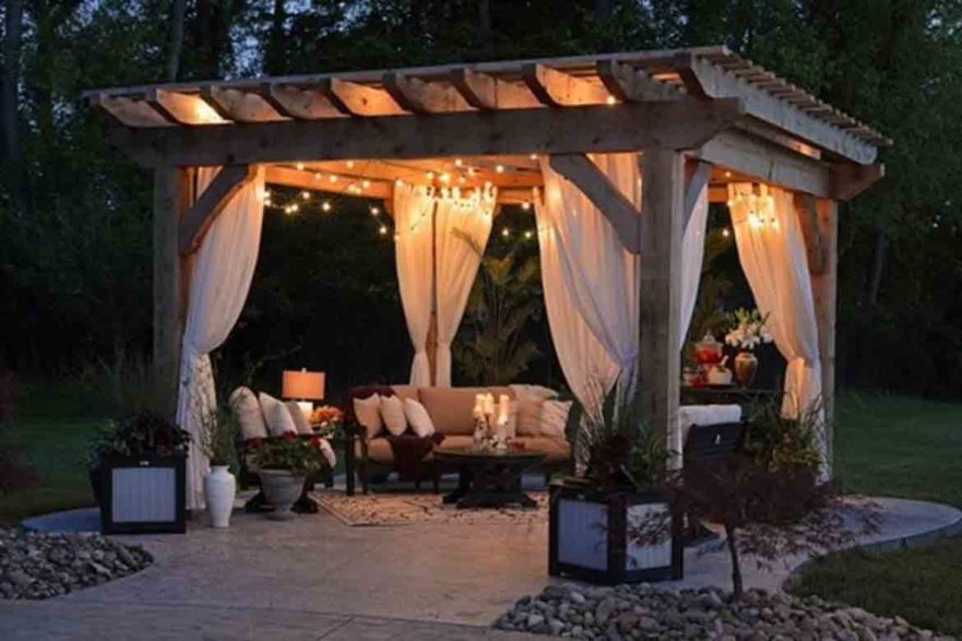 gazebo at night with fairy lights and curtains