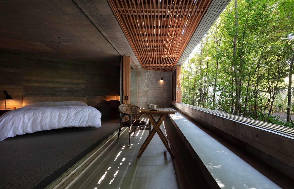 Fuseika House by T-Square Design Associates | The bedroom is on the ground floor where the concrete walls and ceiling give it an almost subterranean feel.
