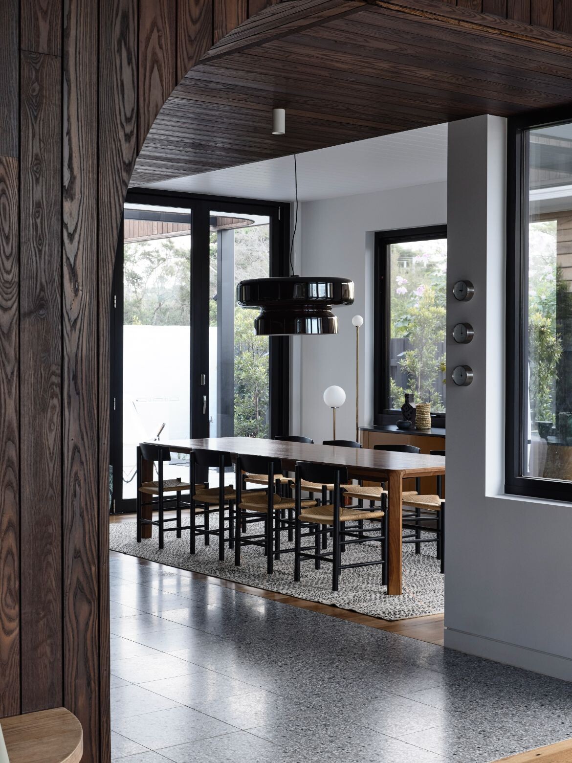 Dark timber and furniture makes the dining area at Sorrento Beach House a stand out by Jost Architects and Simone Haag