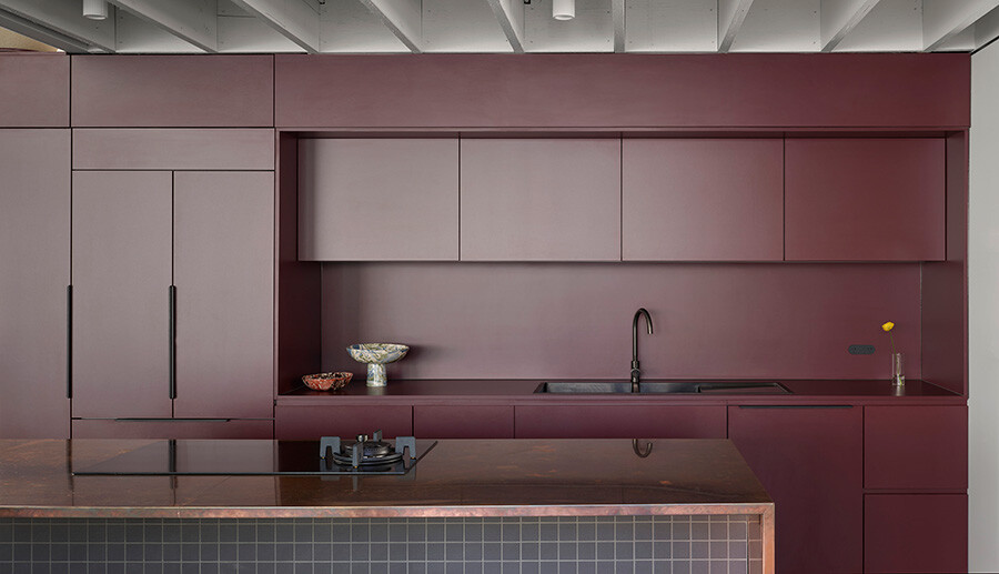 A maroon Laminex kitchen with a copper bench is a stand out at Same Same house