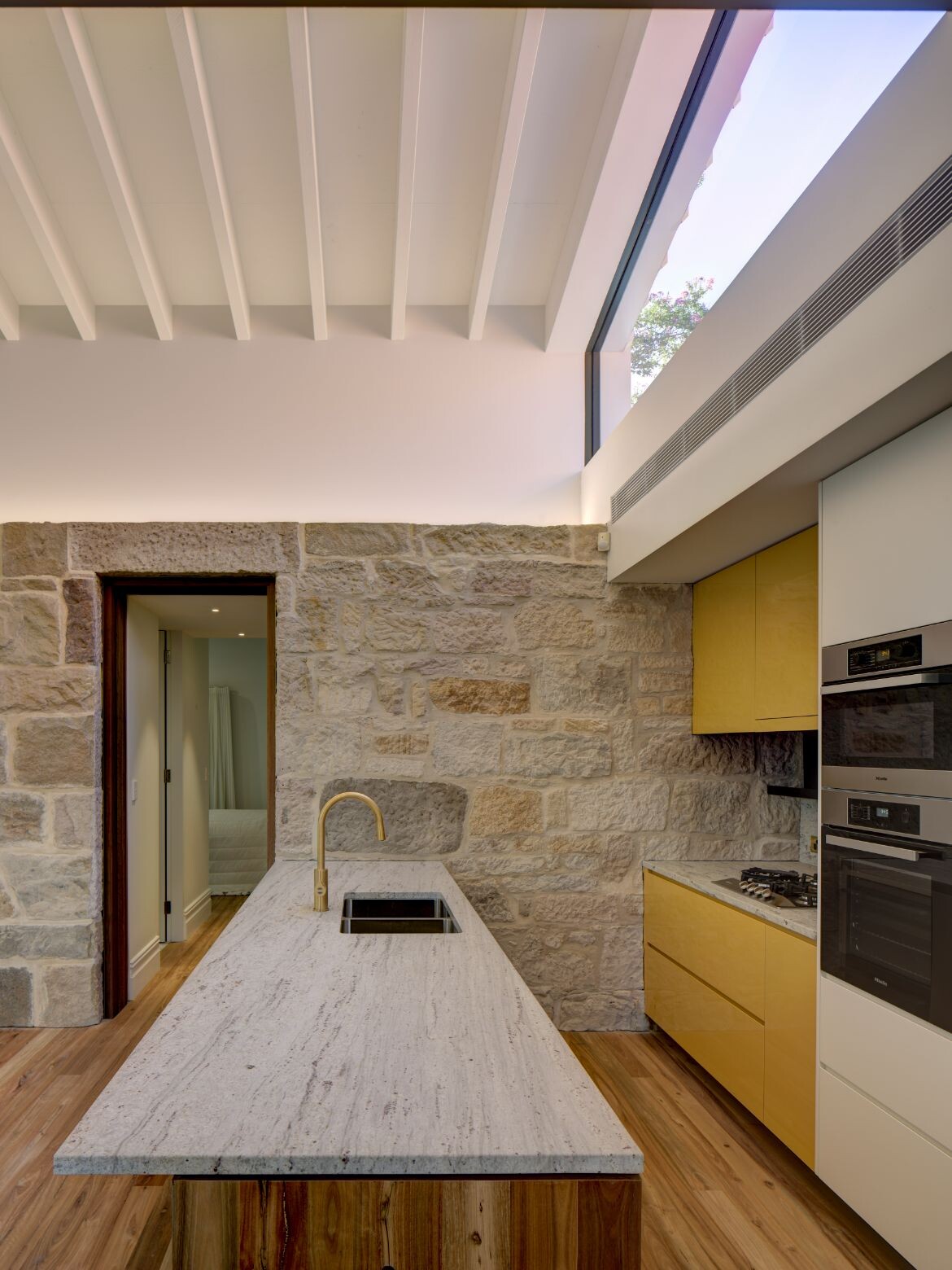 A skylight up high brings natural light into the kitchen at Hunters Hill House by Glyde Bautovich