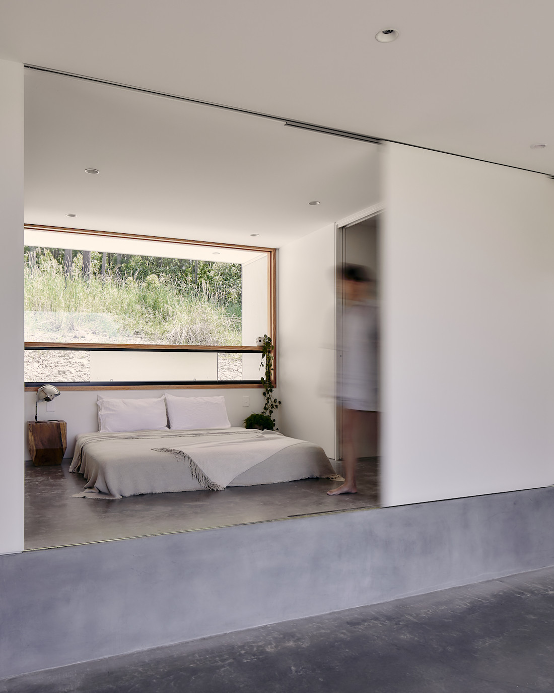 A bed sits on raised, polished concrete floor of the A-CH Yandina Sunrise home.