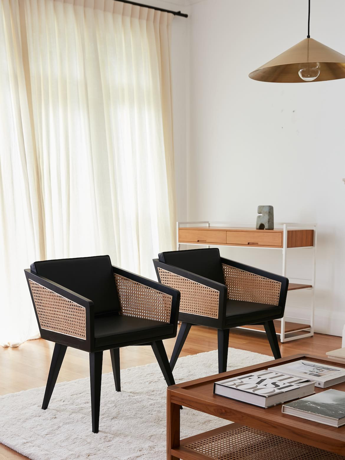 Two angular black chairs with rattan inlays made by Reddie.
