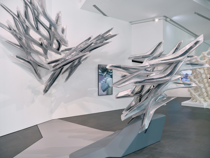 Large abstract silver structures protrude from the walls and floor at Sampling the Future