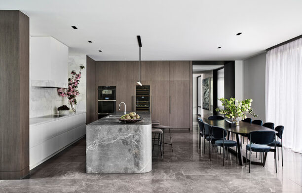 NNH Residence interior design by Mim Design contemporary open-plan kitchen and dining area with natural stone bench and dark cabinetry