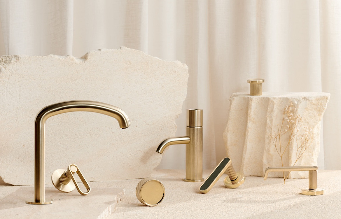 Novas Frame Collection of golden fixtures including two taps and a range of handles and door knobs.