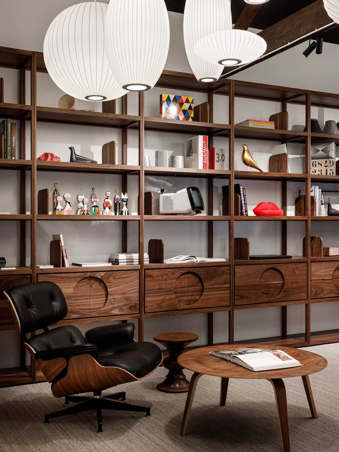 Brown Elan Plus modular Grid Shelving next to an Eames chair and other mid-century furniture.