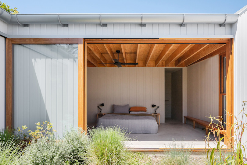 A bedroom that looks onto the courtyard of Tribe Studio Architect's Bundeena Kit-home.